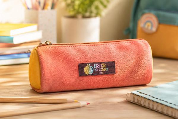 Étiquette en coton bordeaux avec texte arc-en-ciel sur trousse