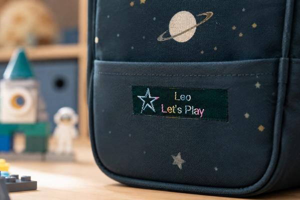 Étiquette en coton vert mousse avec texte arc-en-ciel sur sac enfant