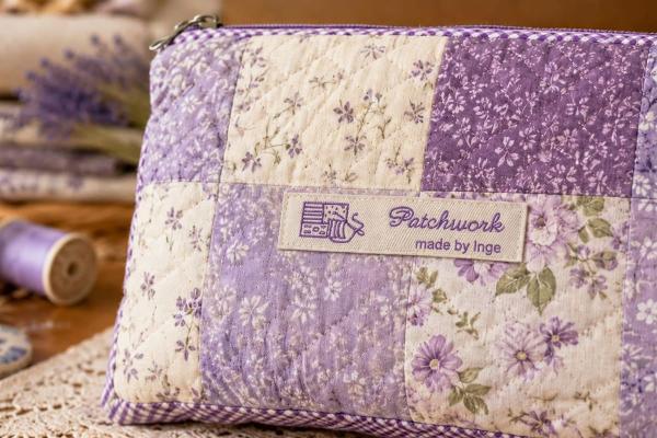 Étiquette en coton naturel avec texte violet sur trousse patchwork